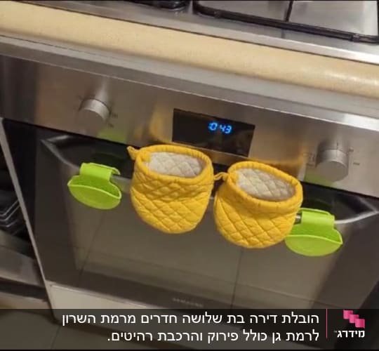 תנור עם כפפות מטבח צהובות על הידית